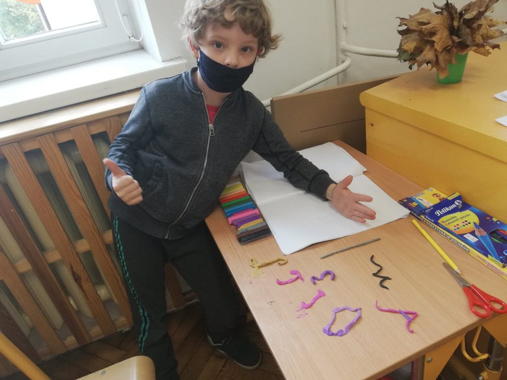 Na zdjęciach uczniowie lepiący z plasteliny poznane literki.