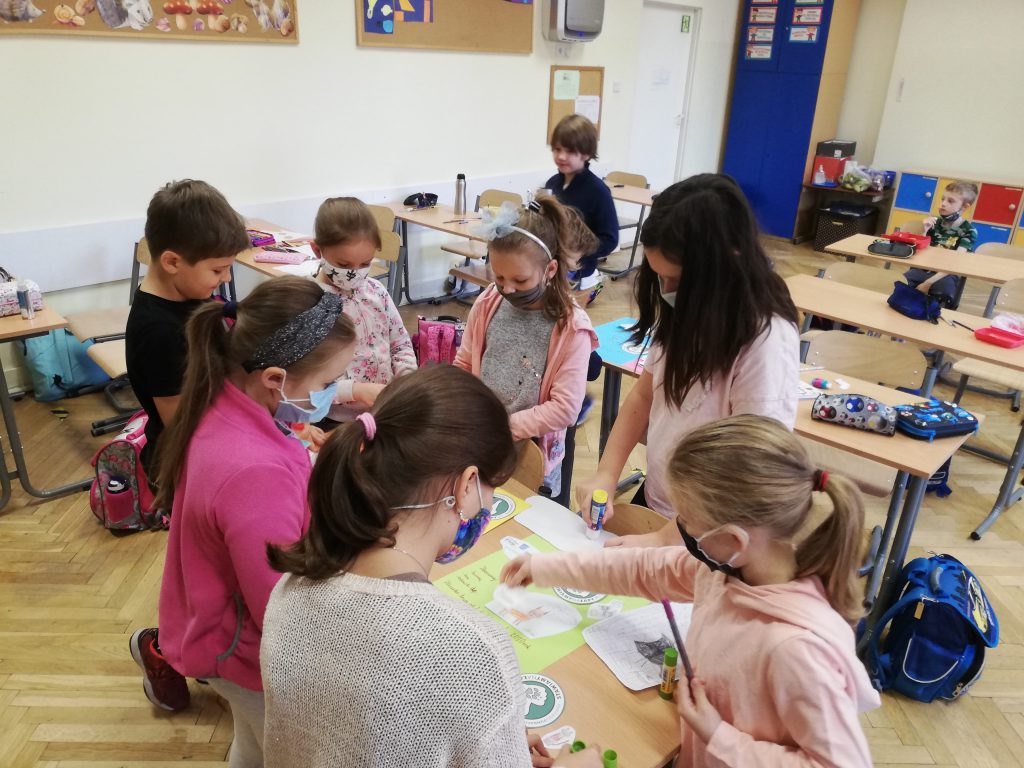Na zdjęciachuczniowie klasy II wykonujący plakaty promujące zbiórkę na rzecz zwierząt.