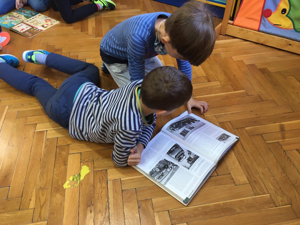 Zdjęcie przedstawia dzieci czytające książkę.
