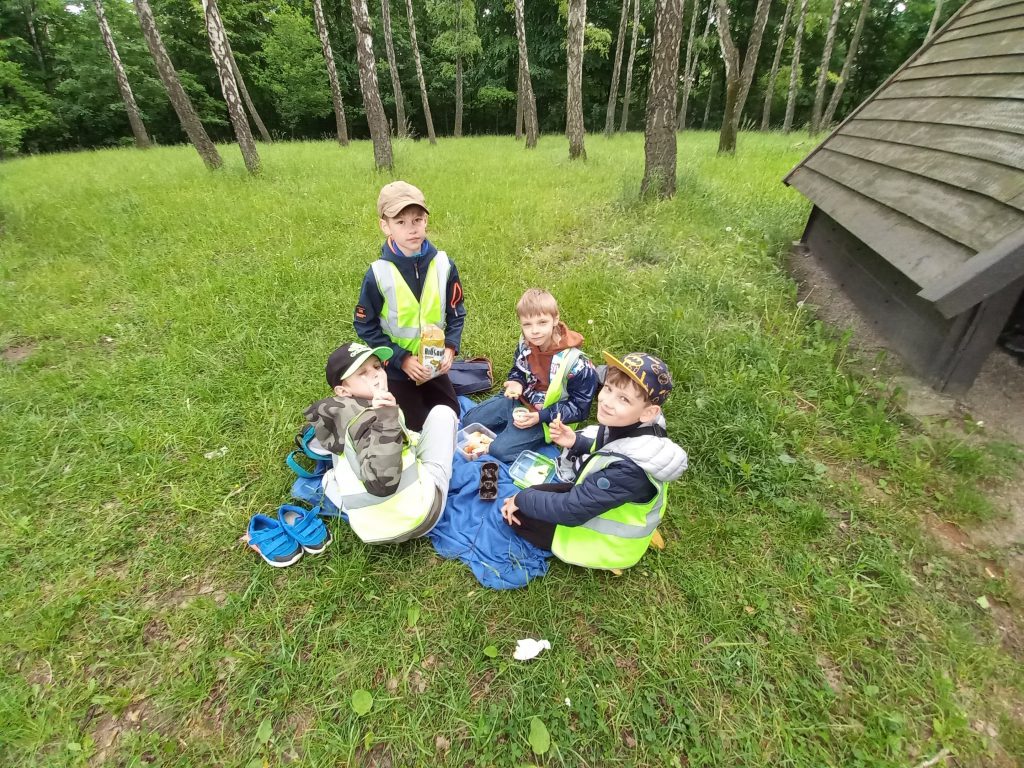 Uczniowie biesiadujący na kocykach.