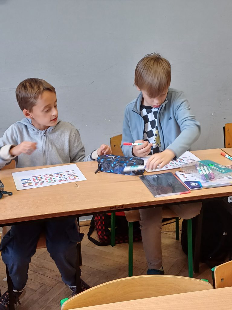 Zdjęcie przedstawia uczniów robiących karty pracy.