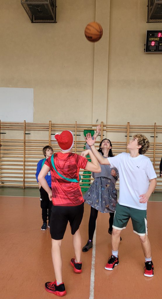 Zdjęcie przedstawia uczniów grających w kosza.