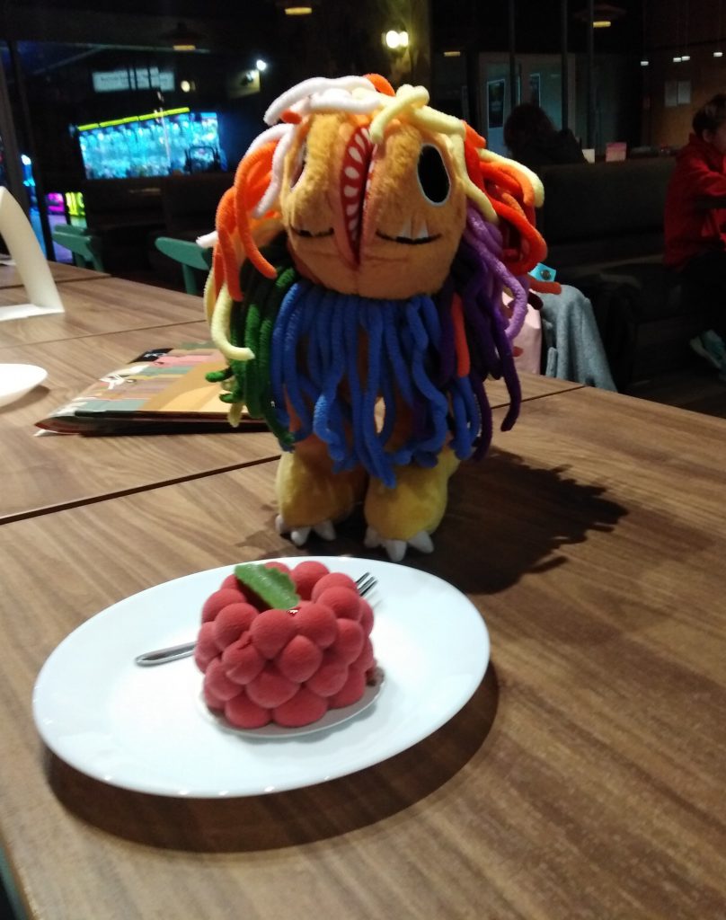 Zdjęcie przestawiające maskotkę i ciastko.