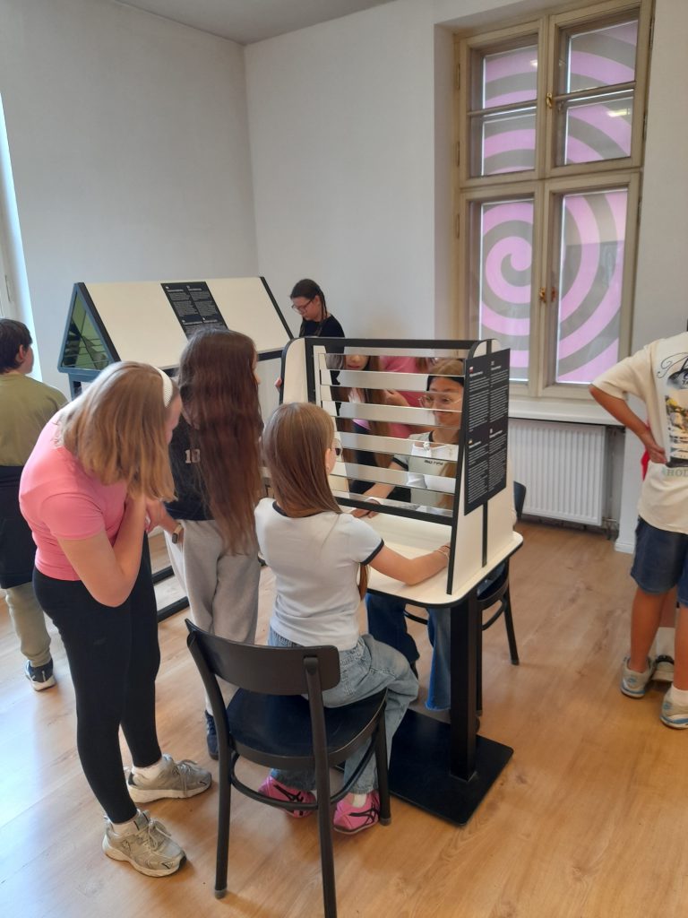 Zdjęcie przedstawia uczniów zwędzających Muzeum Iluzji.